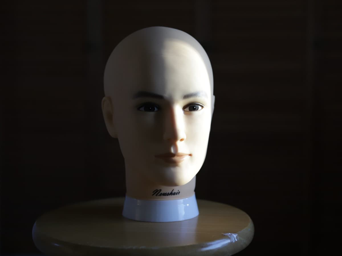Image window light Mannequin head on stool lit up with window light.