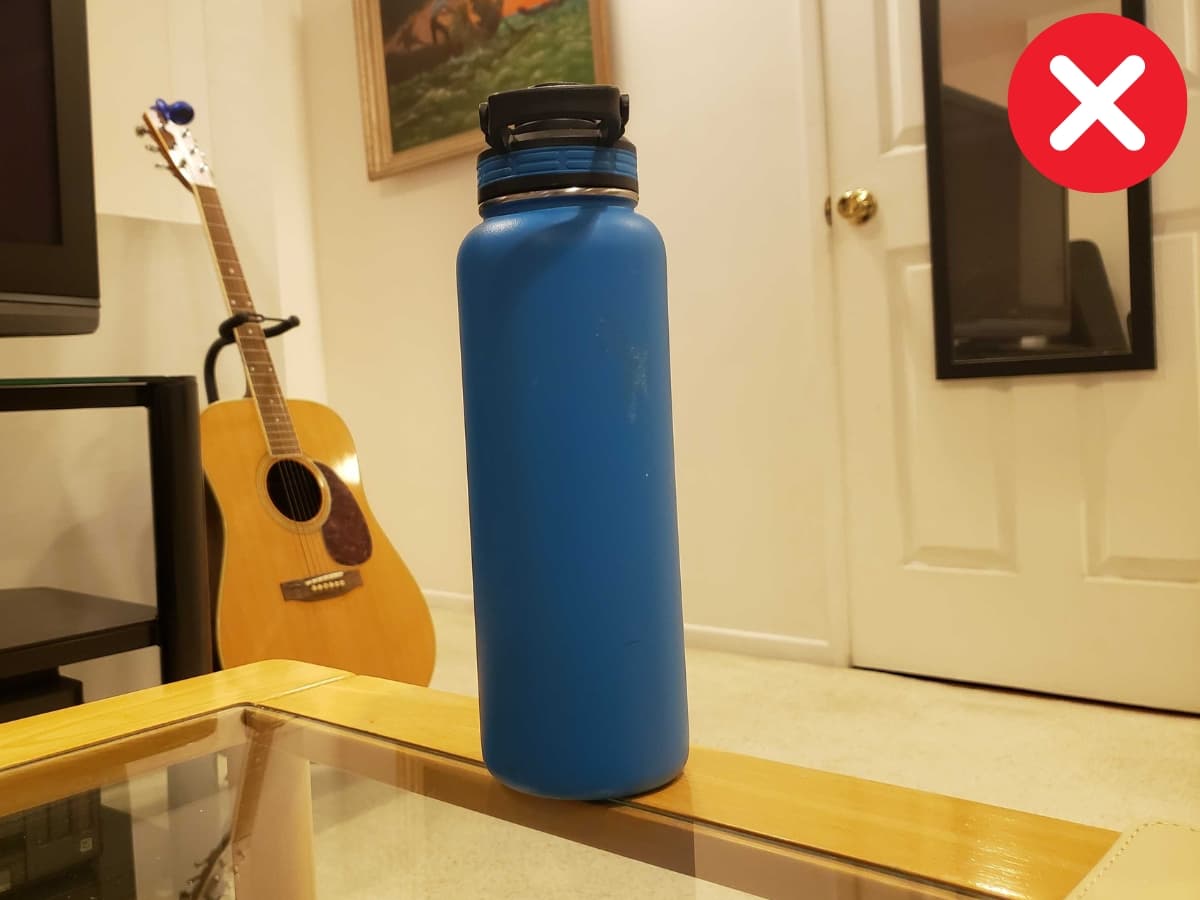 Incorrectly framing on all sides Water bottle on table.