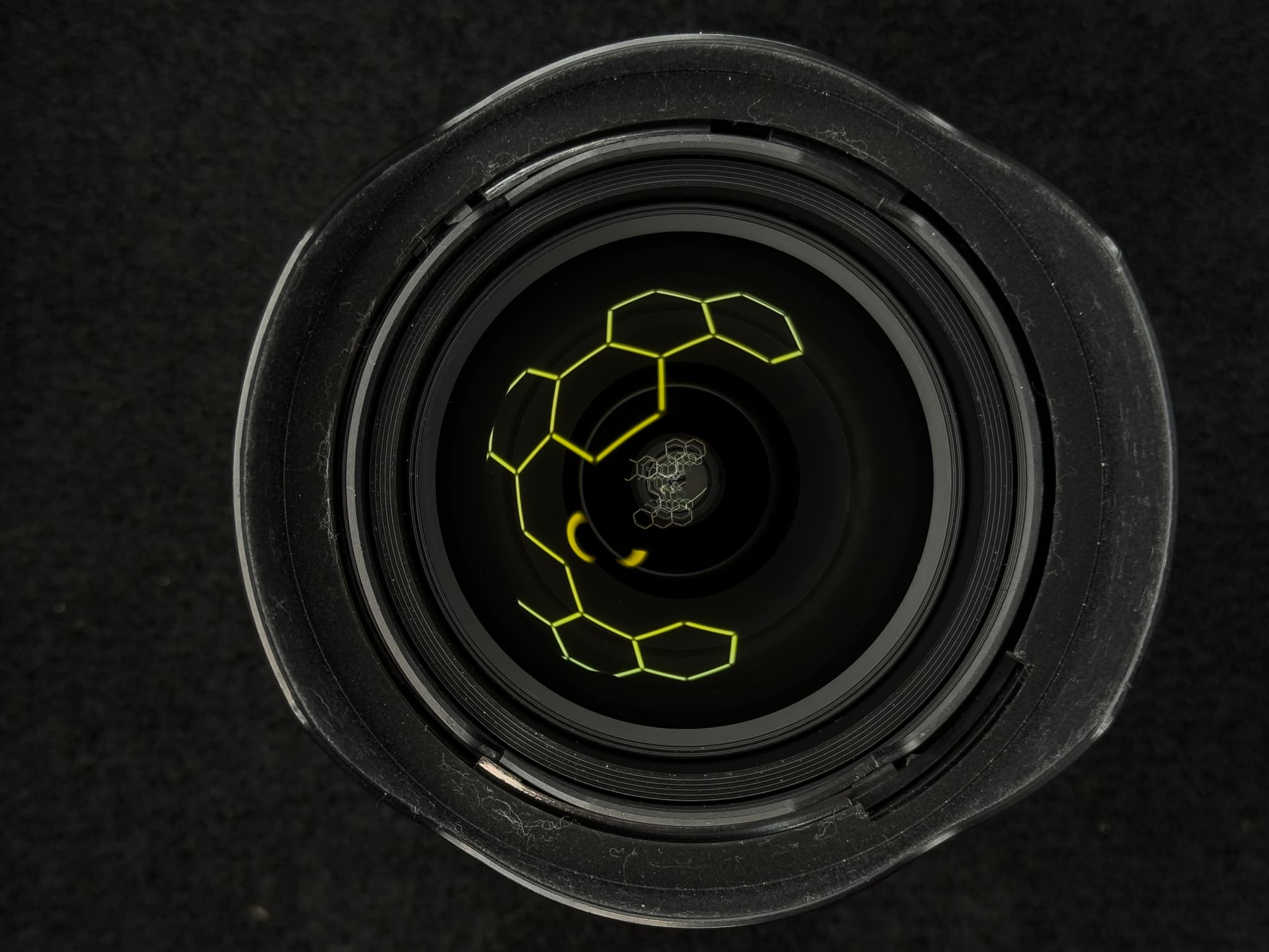 Head-on look into the front element of the Nikon Z 14-24mm f/2.8 S to display the constant f/2.8 physical glass opening and the 9 rounded diaphragm blades