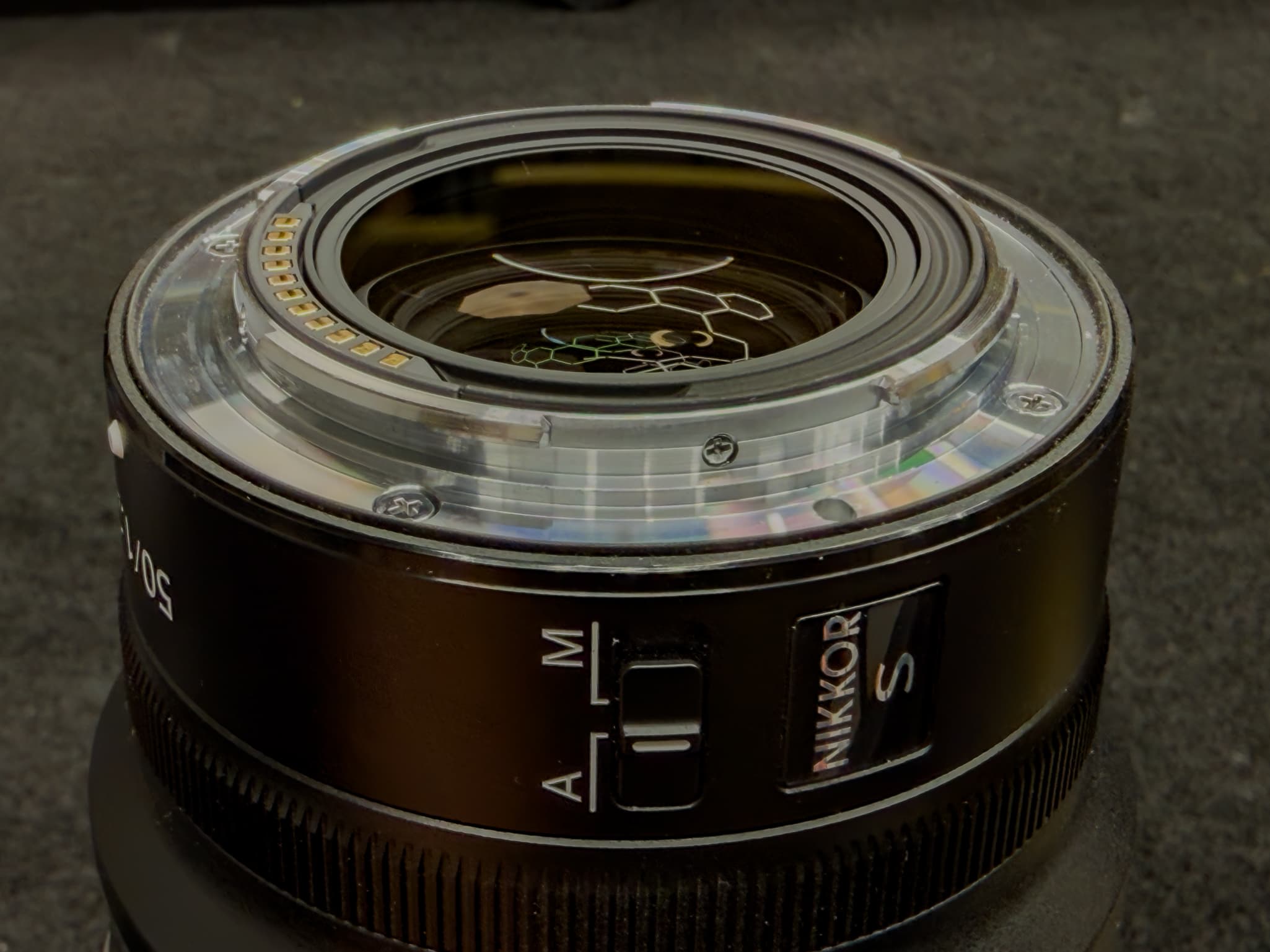 Close-up focusing directly on the thin black rubber weather-sealing gasket lining the outer rim of the rear metal mount of the Nikon Z 50mm f/1.2 S