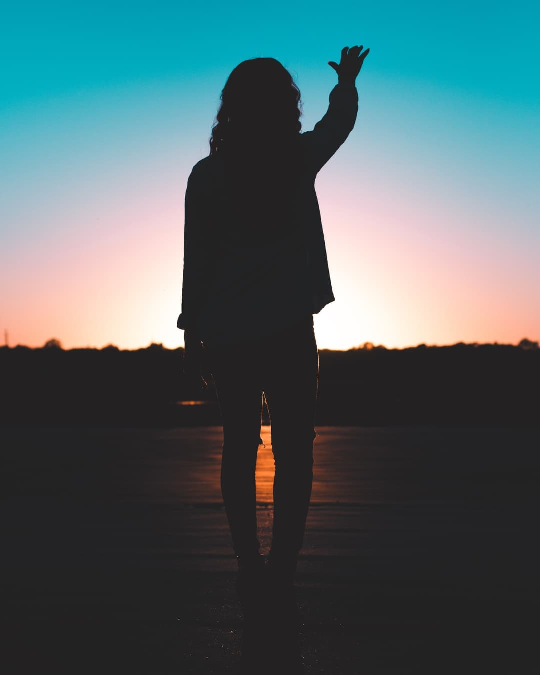 Silhouette during golden hour Woman standing in front of sun creating a silhouette.