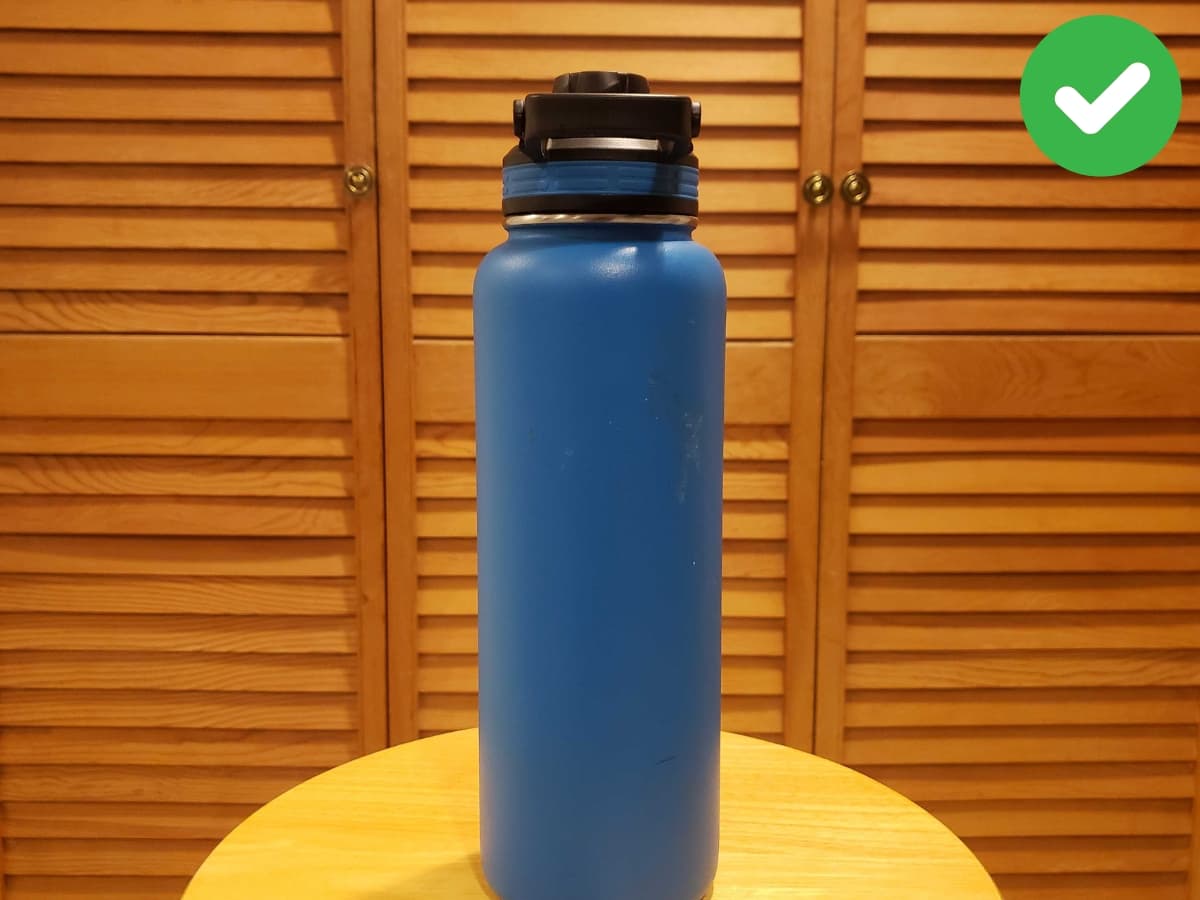 Using framing Water bottle on a wood stool being framed by closet lines behind it.