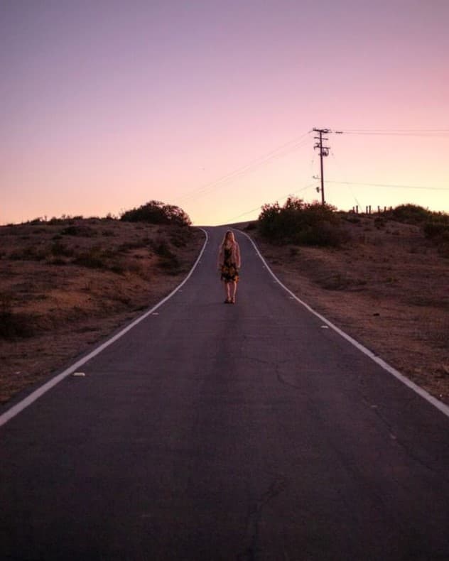 Using negative space with leading lines Woman standing in the middle of the road creating negative space with leading lines.